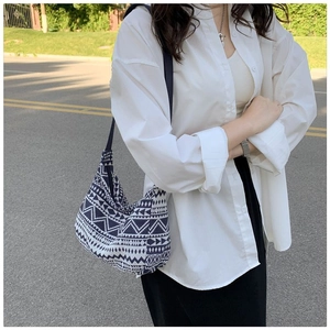 Detail of bohemian geometric canvas tote bag with blue patterns on a shoulder strap