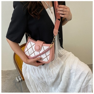 Close-up of pink and white quilted crossbody bag with woven handle and wide canvas strap