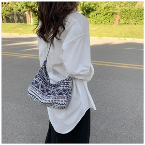 Outdoor shot of a geometric tribal canvas hobo bag with ethnic blue and white patterns