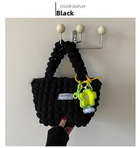 Close-up of black bubble textured tote bag with fashion tag and yellow floral charm