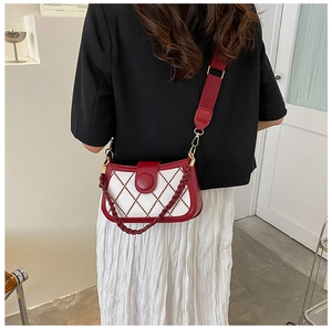 Detail view of red and white lattice bag with adjustable wide shoulder strap on model