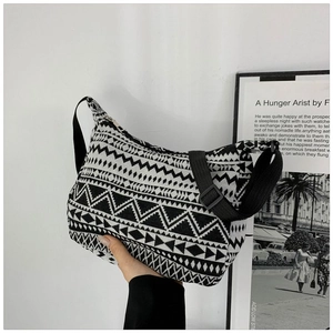 Detail of bohemian geometric pattern on black and white canvas crossbody bag with strap