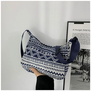 Close-up of geometric pattern crossbody bag with blue and white crescent design