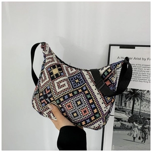 Detail of bohemian geometric knit pattern on hobo bag with adjustable black strap