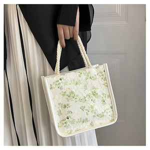 Detail of floral lace texture and woven rope handle on a fresh green canvas handbag