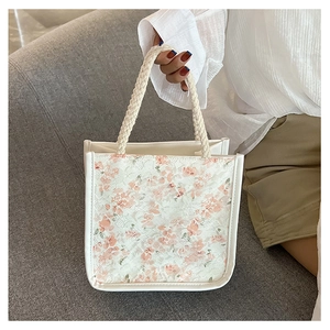 Detail of floral lace texture and braided rope handle on this cute canvas handbag