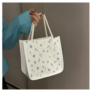 Close-up of floral lace fabric and woven rope handle on a cute canvas tote bag