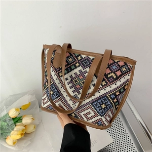 Macrodetail van geometrische jacquardstof en bruin lederen handvat op een boho-tas