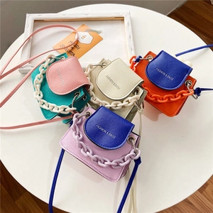 Detalle de mini bolsos de princesa en rosa, blanco, naranja y púrpura con cadenas