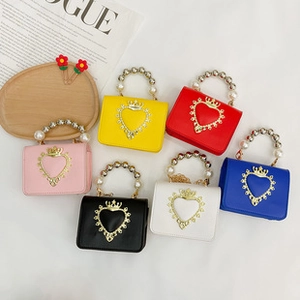 Detalle de mini bolsos coloridos con asas de perlas de lujo y detalles de corazón dorado