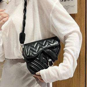 Quilted black saddle bag with wide woven strap and gold ring detail for women