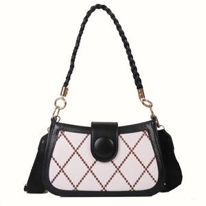 Chic quilted crossbody bag with woven handle and contrast stitching in black and white