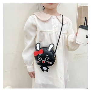 Niña pequeña con bolso bandolera de conejo negro con detalle de lazo rojo