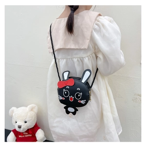 Detalle de bolso bandolera de conejo negro con lazo rojo para niña pequeña