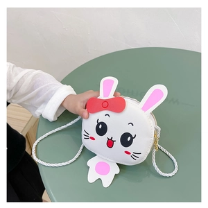 Detalle del bolso de conejo blanco con orejas rosas y lazo rojo para niñas