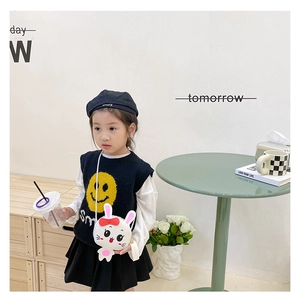 Niña con chaleco negro smile y un bolso bandolera blanco con forma de conejo