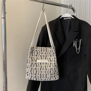 Dettaglio della borsa a tracolla intrecciata bianca e nera con marchio Fashion