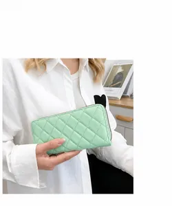 Dettaglio del portafoglio lungo trapuntato verde menta in pelle PU con zip
