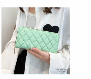Primo piano del portafoglio trapuntato verde menta con cerniera e design elegante da donna