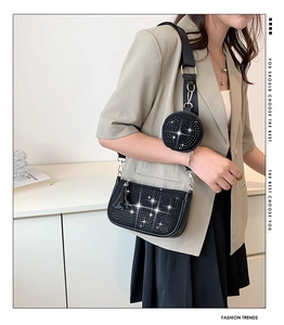 Detail of black rhinestone shoulder bag with matching round charm and tassel zipper