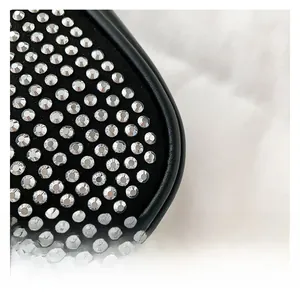 Detail of silver rhinestones on black fabric with leather trim and precise stitching