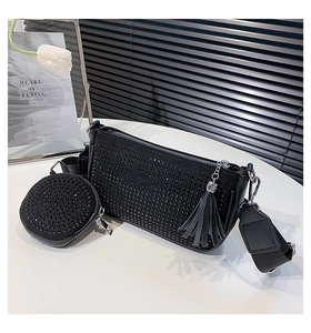 Close-up of black studded shoulder bag with mini coin purse and leather tassels
