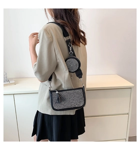 Detail of black rhinestone crossbody bag with wide shoulder strap and round coin purse