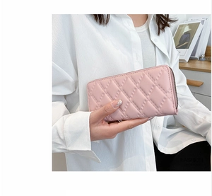 Dettaglio della pochette rosa trapuntata da donna con zip in metallo ed elegante