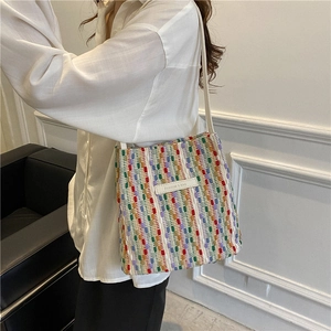 Borsa tote minimalista in tela colorata intrecciata con etichetta in pelle e tracolla