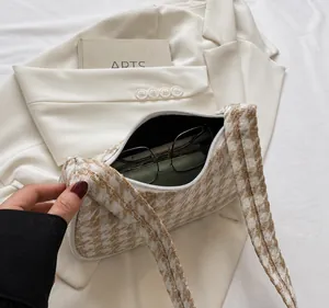 Detail van de capaciteit van de houndstooth schoudertas met bril op een witte blazer