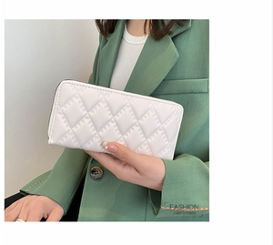 Portafoglio lungo in pelle PU bianca trapuntata tenuto da modella per stile moda