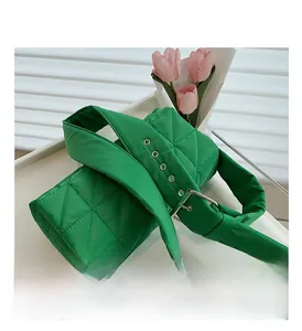 Detail view of grass green quilted cotton shoulder bag with wide strap and metal buckle