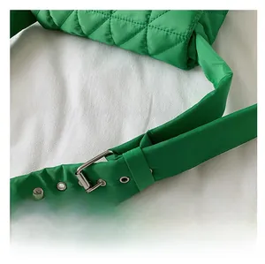 Detail of green quilted shoulder bag with adjustable strap and silver metal buckle