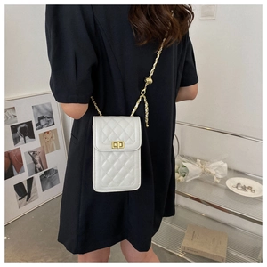 Close-up of a white quilted crossbody phone bag with gold clasp on a female model