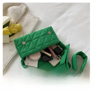 Green quilted shoulder bag with magnetic buckle showing spacious internal capacity
