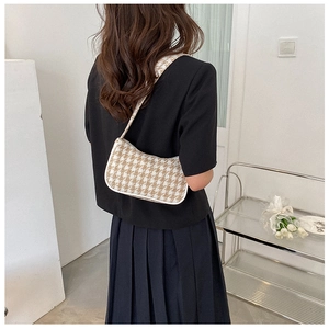 Klassieke houndstooth schoudertas met witte leren bies getoond op model voor pasvorm