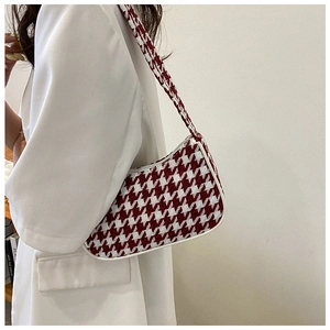 Detail van rood-witte pied-de-poule textuur en biezen op de trendy schoudertas