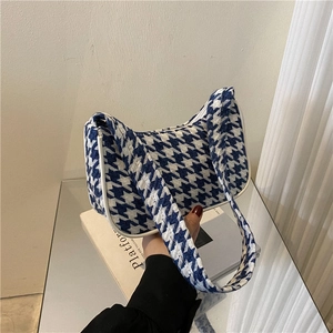 Detailopname van blauw-witte houndstooth schoudertas met geweven stoffen textuur