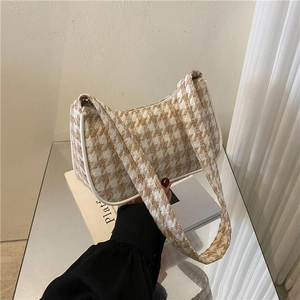 Gedetailleerd zicht op vintage geruite hobo tas met witte lederen bies en getextureerde stof