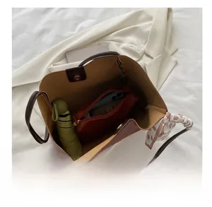 Internal capacity of brown tote bag with umbrella, phone, and silk scarf detail