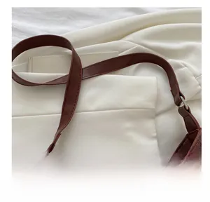 Detail view of brown vintage shoulder bag with precise stitching and silver metal hardware