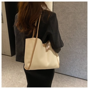 Detail of cream large tote bag with brown piping and pink polka dot silk scarf handle