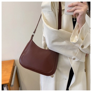 Deep brown matte hobo bag with adjustable strap styled on a minimalist trench coat