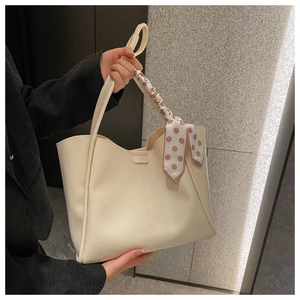 Detailed view of off-white PU leather tote bag with elegant polka dot silk scarf handle