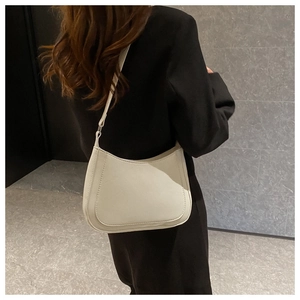 Close-up of cream underarm bag featuring contrast stitching and adjustable shoulder strap