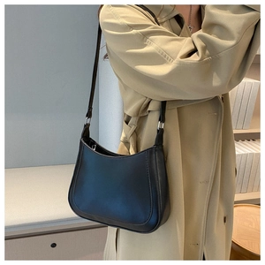 Detail view of a black crescent shoulder bag in smooth PU leather with fine stitching