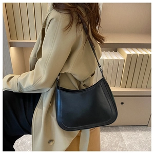 Detail shot of a vintage black crescent underarm bag with smooth matte leather finish