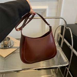 Detail view of smooth dark brown vintage crescent moon faux leather underarm bag