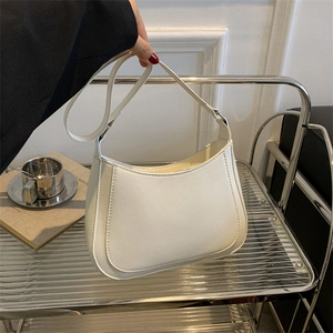 Detailed close-up of a white crescent shoulder bag with matte finish and stitching details