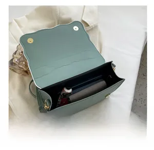 Internal view of green pleated handbag showing space for phone, wallet and cosmetics